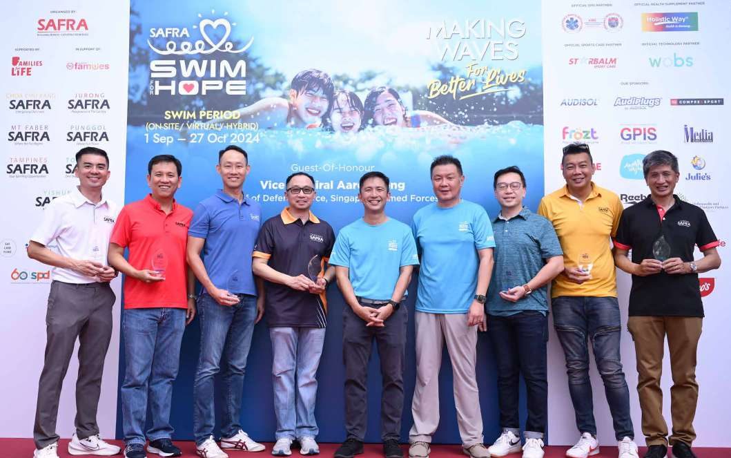 Prize presentation on stage at the SAFRA Swim for Hope charity event, with sponsors, organisers and Guest-of-Honour Vice Admiral Aaron Beng.
